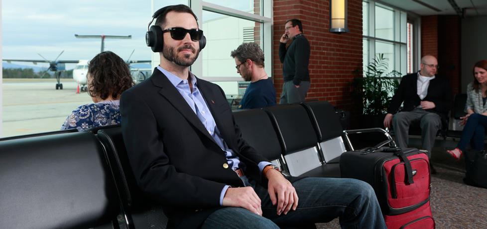 Man listening to music in an airport.