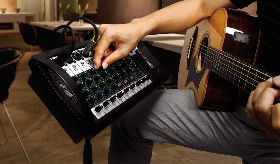 acoustic guitar player adjusting Yamaha StagePas mixer
