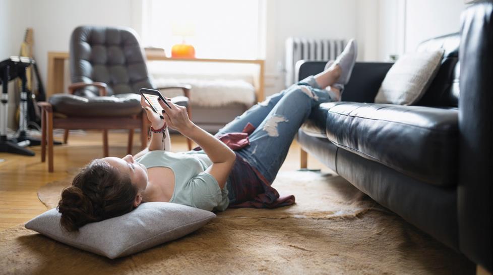 Woman relaxing on floor using phone app