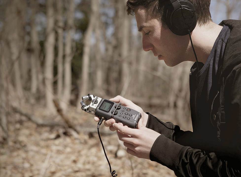 Man outside making field recordings
