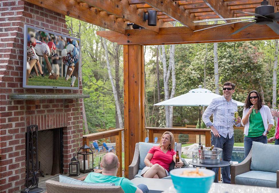 People enjoying a football game on an outdoor TV