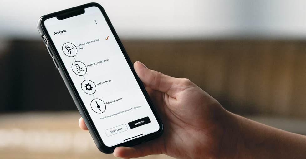 Person holding a phone with the Sony hearing aid app on the screen