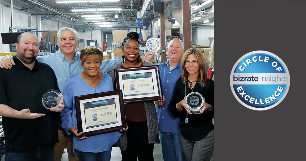 employees in a warehouse holding awards