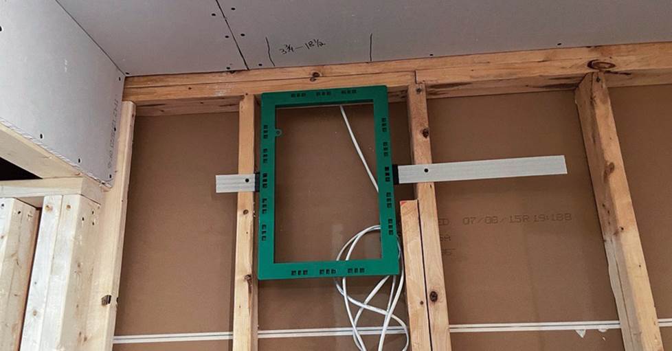 A pre-construction in-wall speaker bracket.