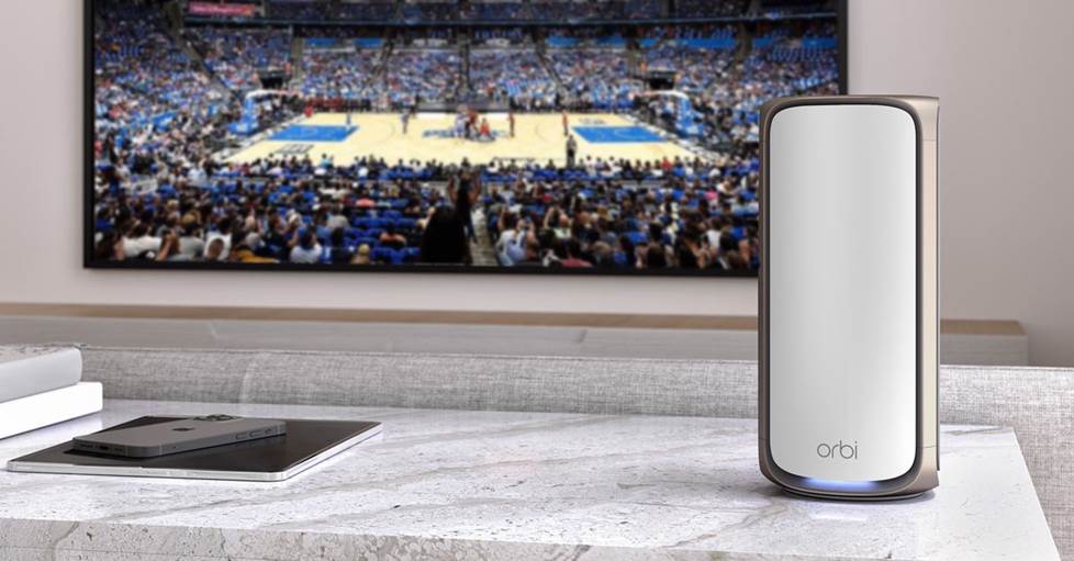 Netgear Orbi 970 in front of a TV with a basketball game on the screen