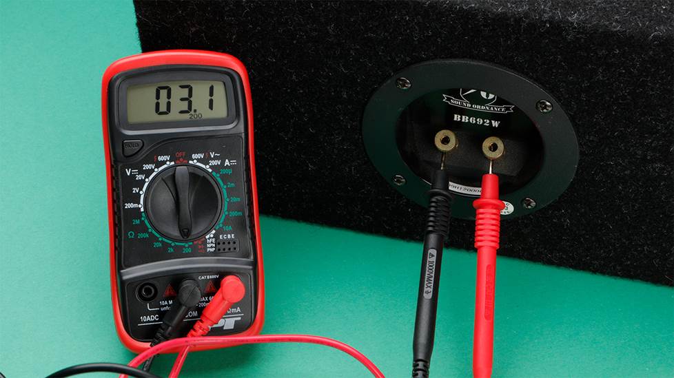 Multimeter with probes attached to speaker binding posts