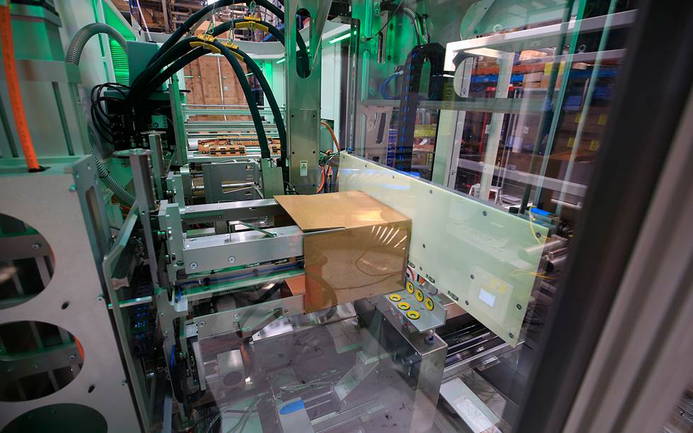 A Pack Size packing machine folds a custom cut box for a Crutchfield order.