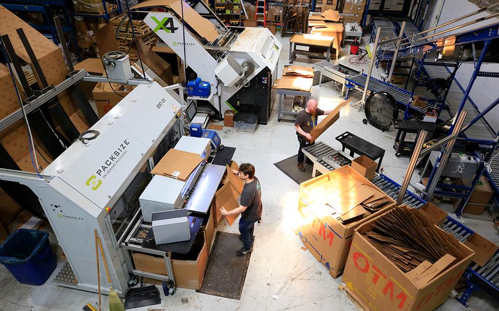 Two large packing machines are run by two Crutchfield employees.