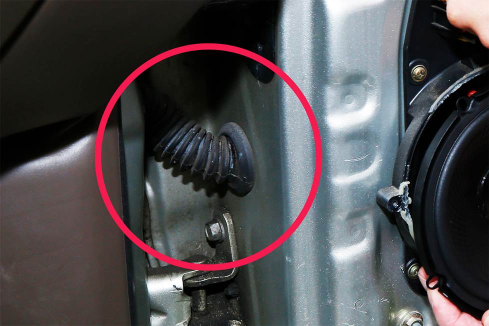 Close up of rubber boot near car door hinge highlighted with red circle