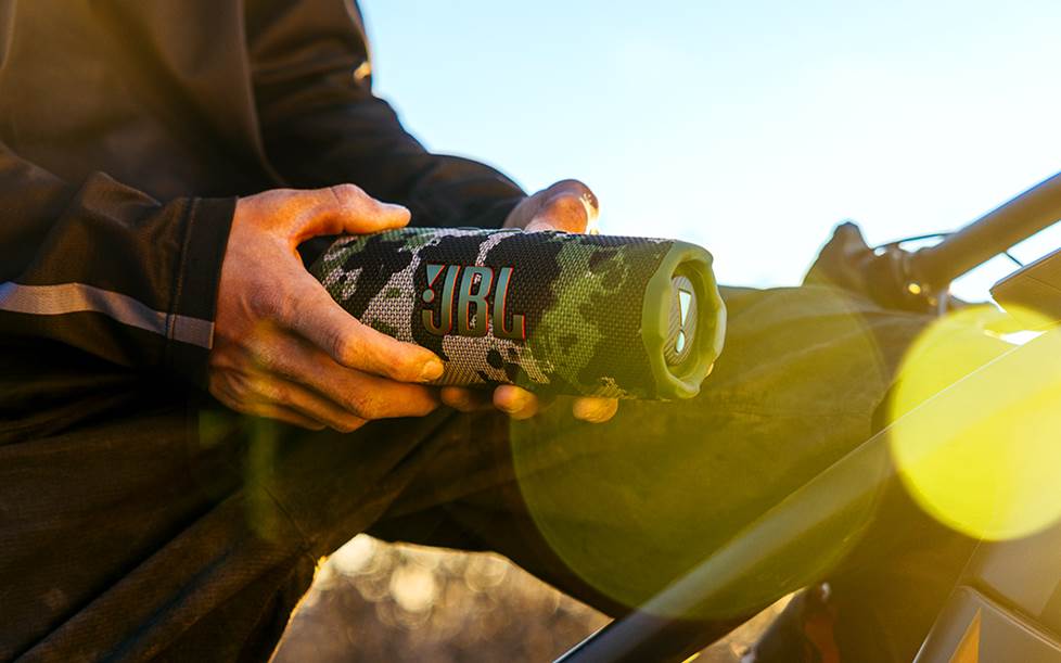 JBL Flip 7 speaker held by mountain biker