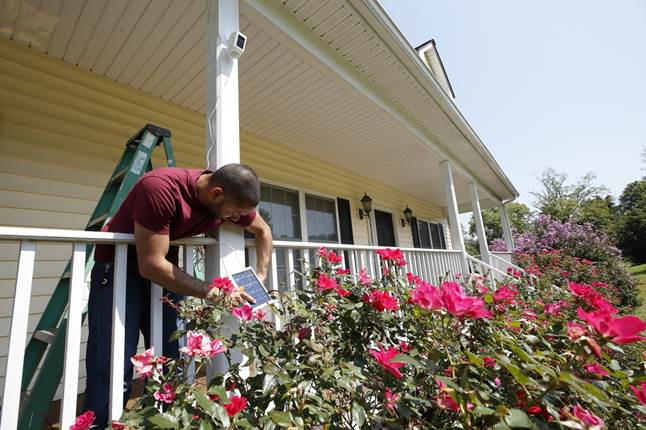 Advisor Carlos installs Ring Spotlight Cam Battery and Solar Panel bundle on his front porch.