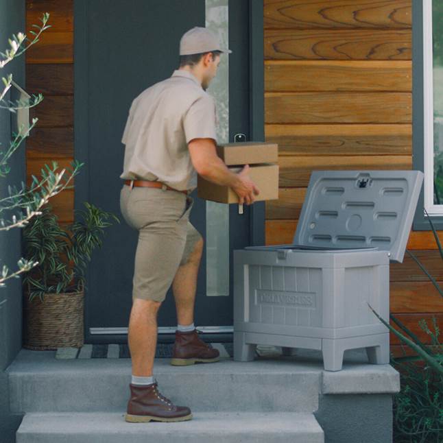 UPS guy putting packages in Yale Kent Smart Delivery Box on porch