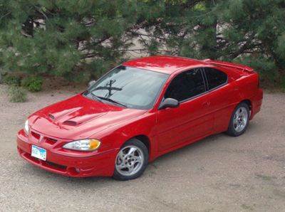 Picture of a red 2003 Pontiac Grand Am GT in a driveway