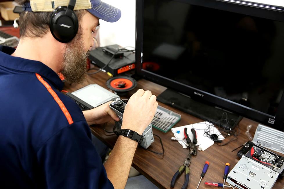 Photo of 2nd life employee taking apart electronic equipment.