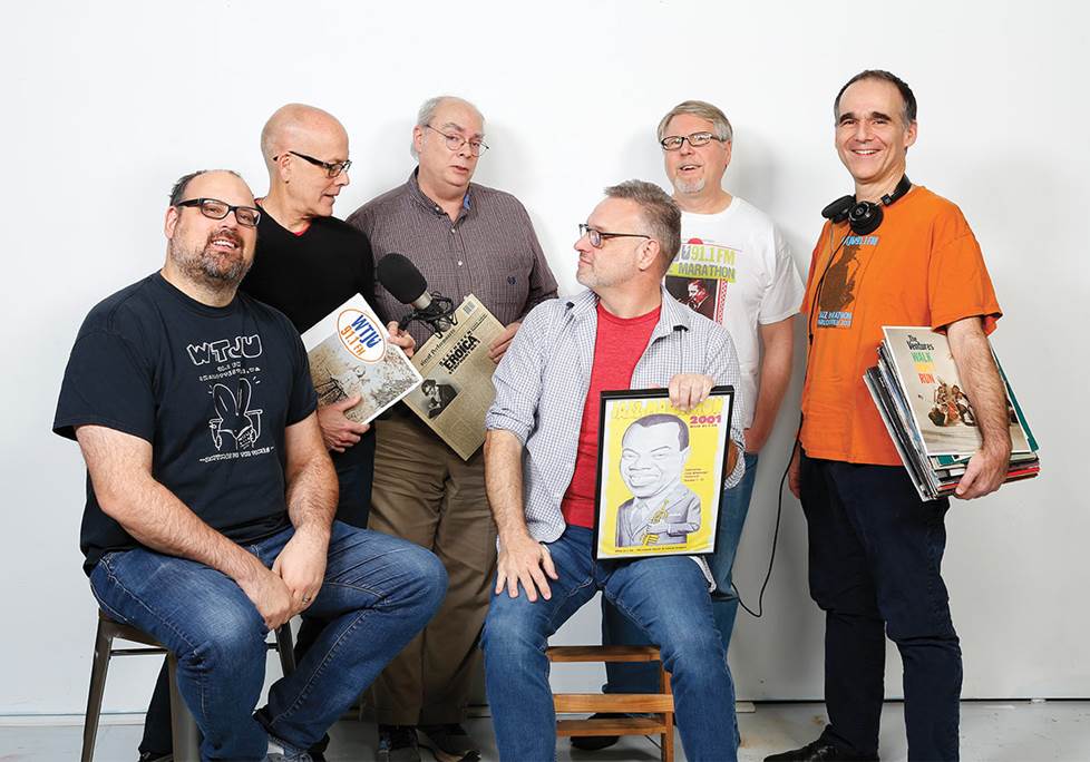 six guys posing with records and broadcast gear