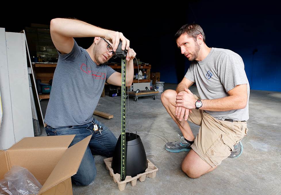 two men measuring a speaker