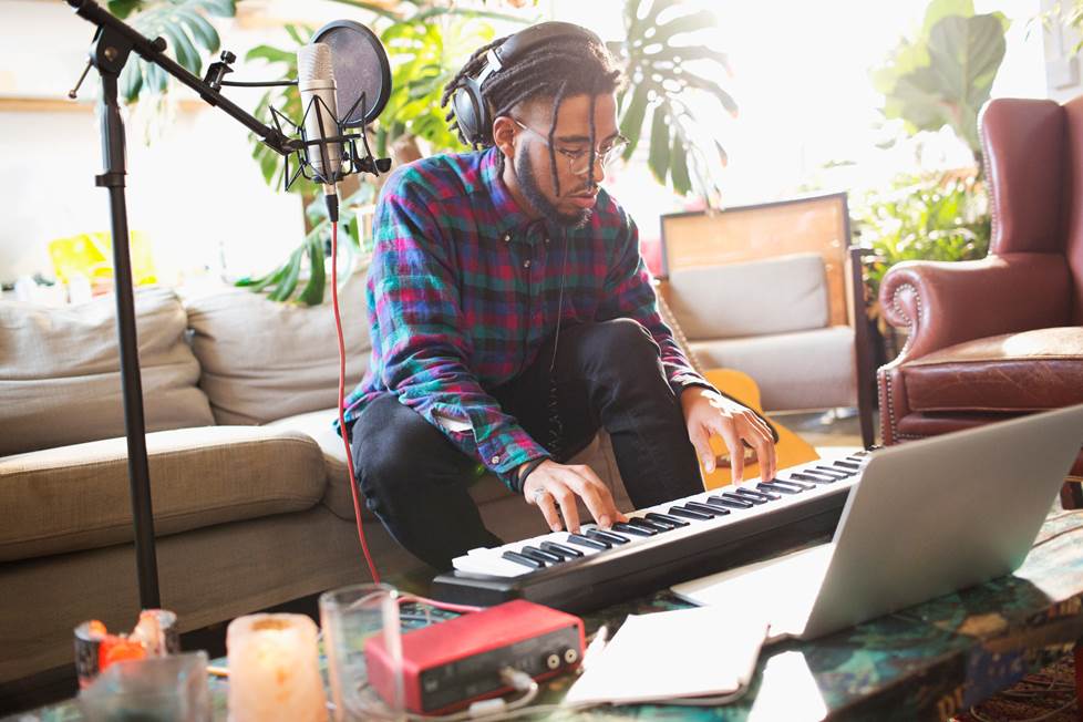 man recording music in his apartment