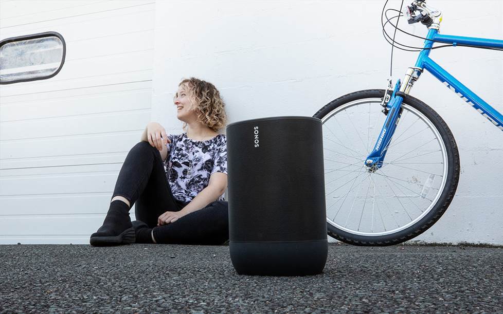 Woman outside with Sonos Move and bicycle