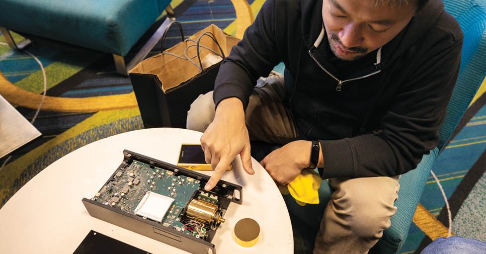Tomo Sato, showing Jeff the internal circuit boards of the DMPZ1 headphone amp