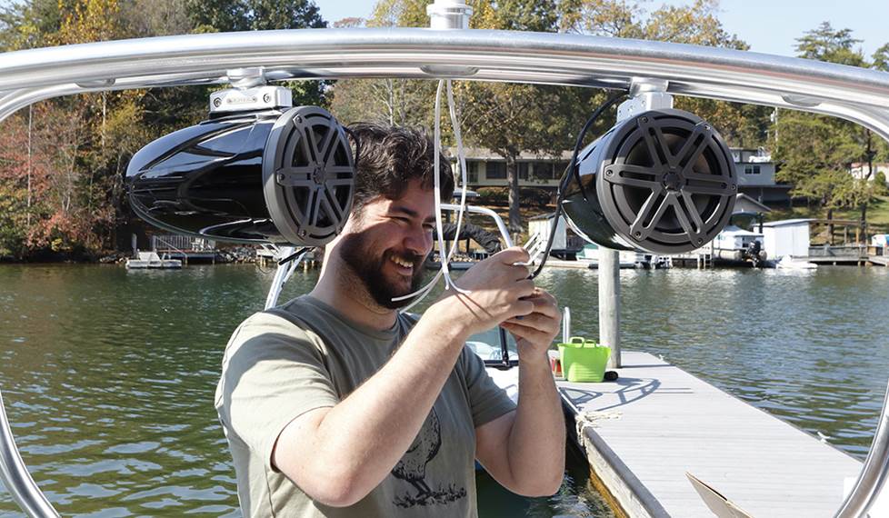 Editor Matt installing a tower speaker on a boat.
