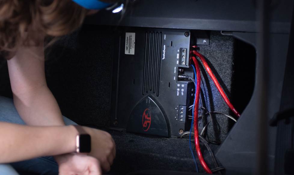 Woman installing a car amp