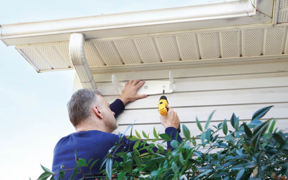 speakers shown mounted under the eaves of a house