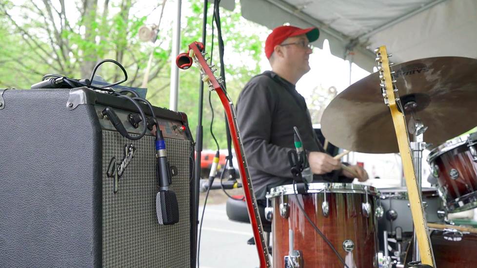 Band stage setup, focused on a guitar amp with a microphone on the speaker