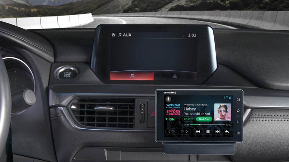 SXM add-on tuner mounted on a car dash next to the car stereo receiver