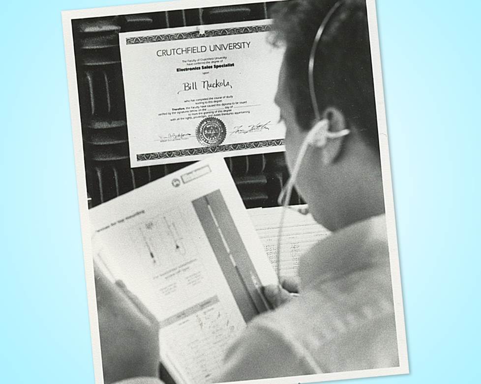 black and white photo of salesperson on the phone with a "Crutchfield University" diploma on the wall