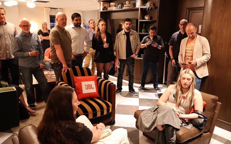 Group listening intently to new JBL speakers.