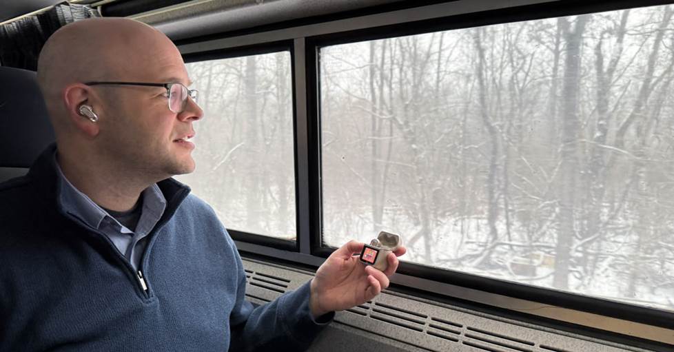 Jeff on the train wearing the JBL Tour Pro 3s, with the case in his hand