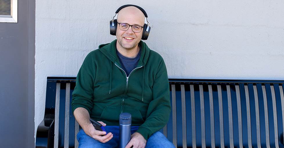 Jeff sitting on a bench wearing the Sennheiser HDB 630 headphones