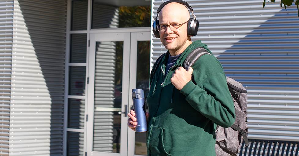 Jeff wearing Sennheiser HDB 630 headphones in front of Crutchfield contact center