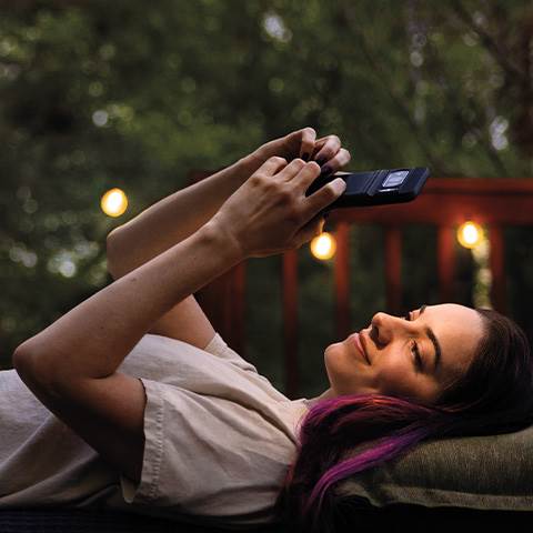 Rayna creates a playlist while relaxing on the porch.
