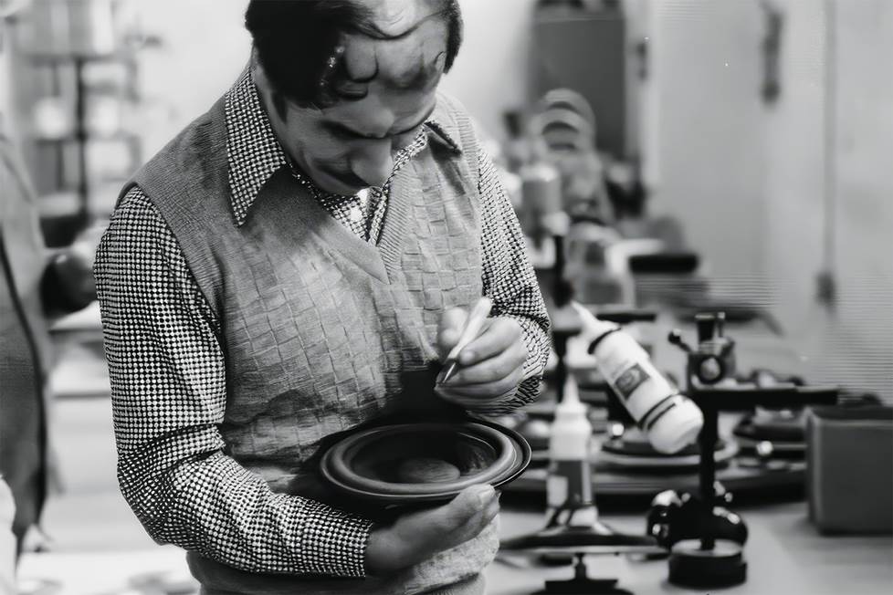 vintage b;ack and white photo of man in factory with speaker driver