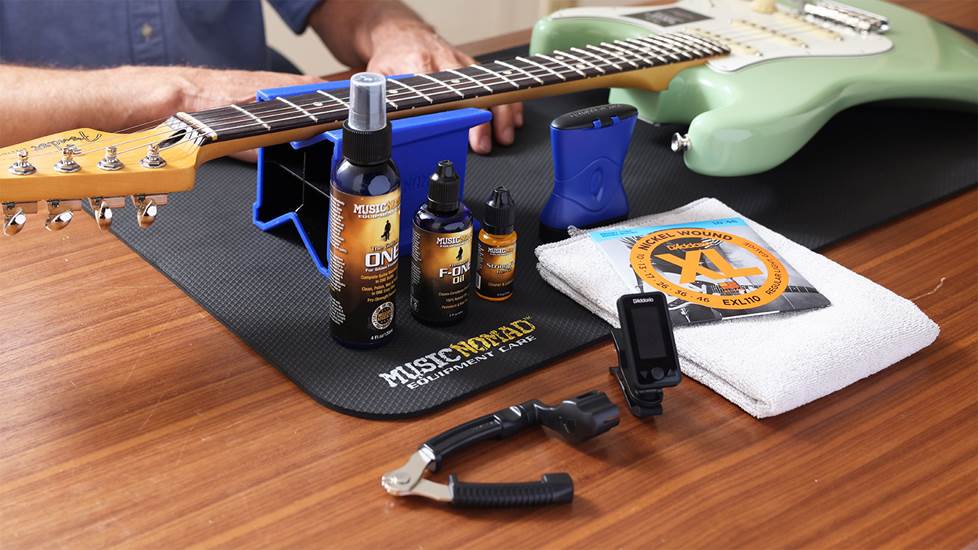 assortment of guitar tools and accessories on a table with a guitar