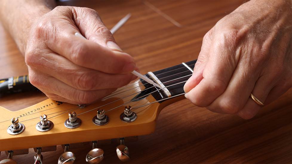 applying lubricant to guitar nut