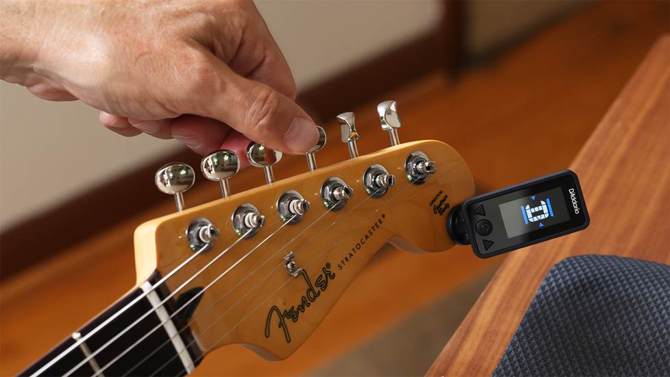 tuning a guitar string to pitch with a clip-on tuner