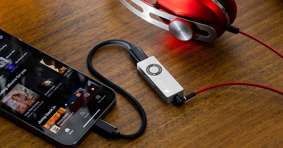 Audioengine DAC3 USB DAC/headphone amp on a table with headphones and phone