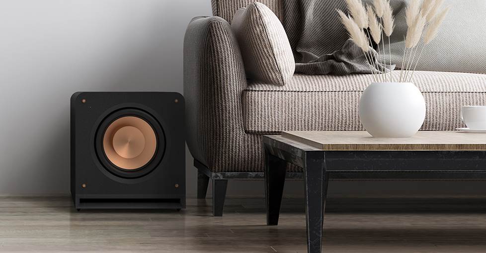 Klipsch RP-1200SW subwoofer sitting next to a couch