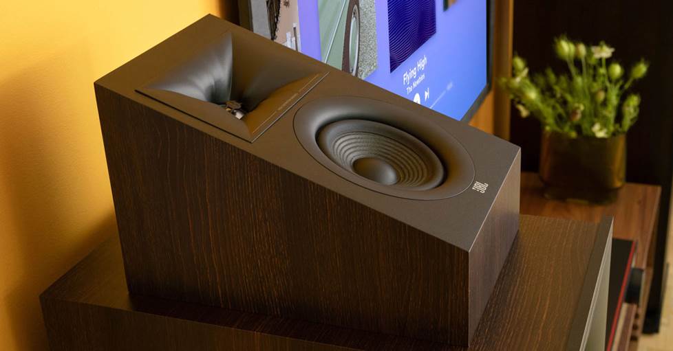 A JBL Stage 240H Dolby Atmos® enabled add-on height module speaker sitting on top of a JBL front-left speaker