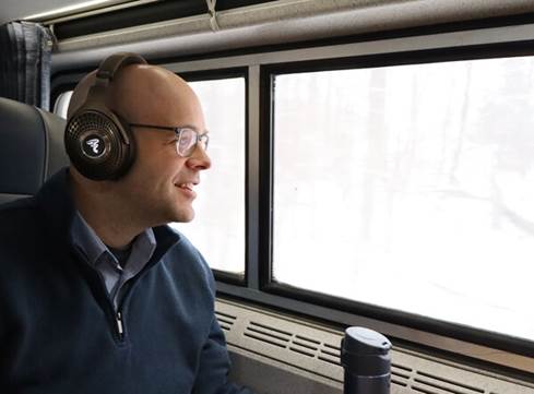 Author riding on train wearing Bathys MG, looking peacefully out window