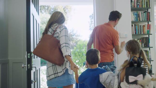 Family enables Ring Alarm system on keypad as they leave through front door.