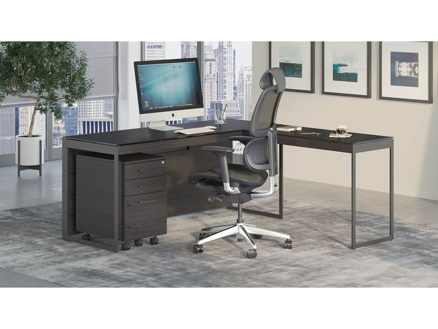 Executive desk with monitor and ergonomic chair in office