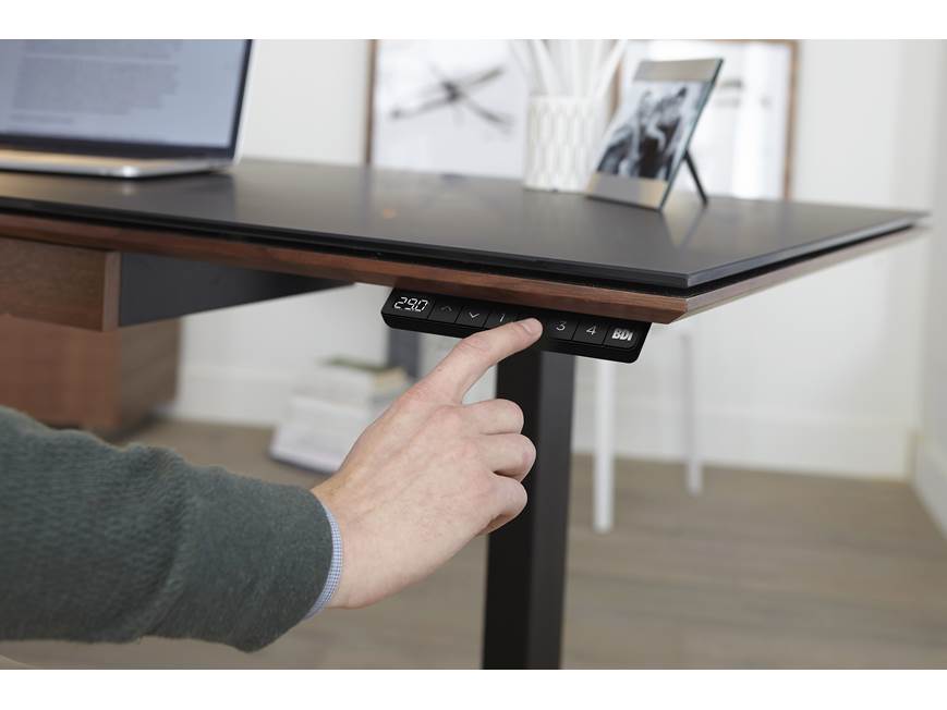 Person adjusting desk height, numeric display