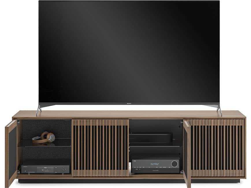 TV sitting on walnut cabinet with doors